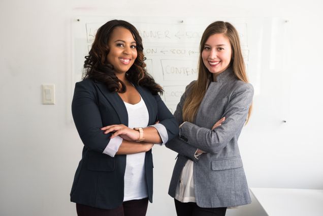 Two women standing next to each other with arms crossed