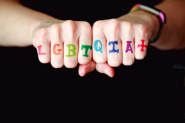 Two fists with the word: LGBTQIA+ written on the knuckles