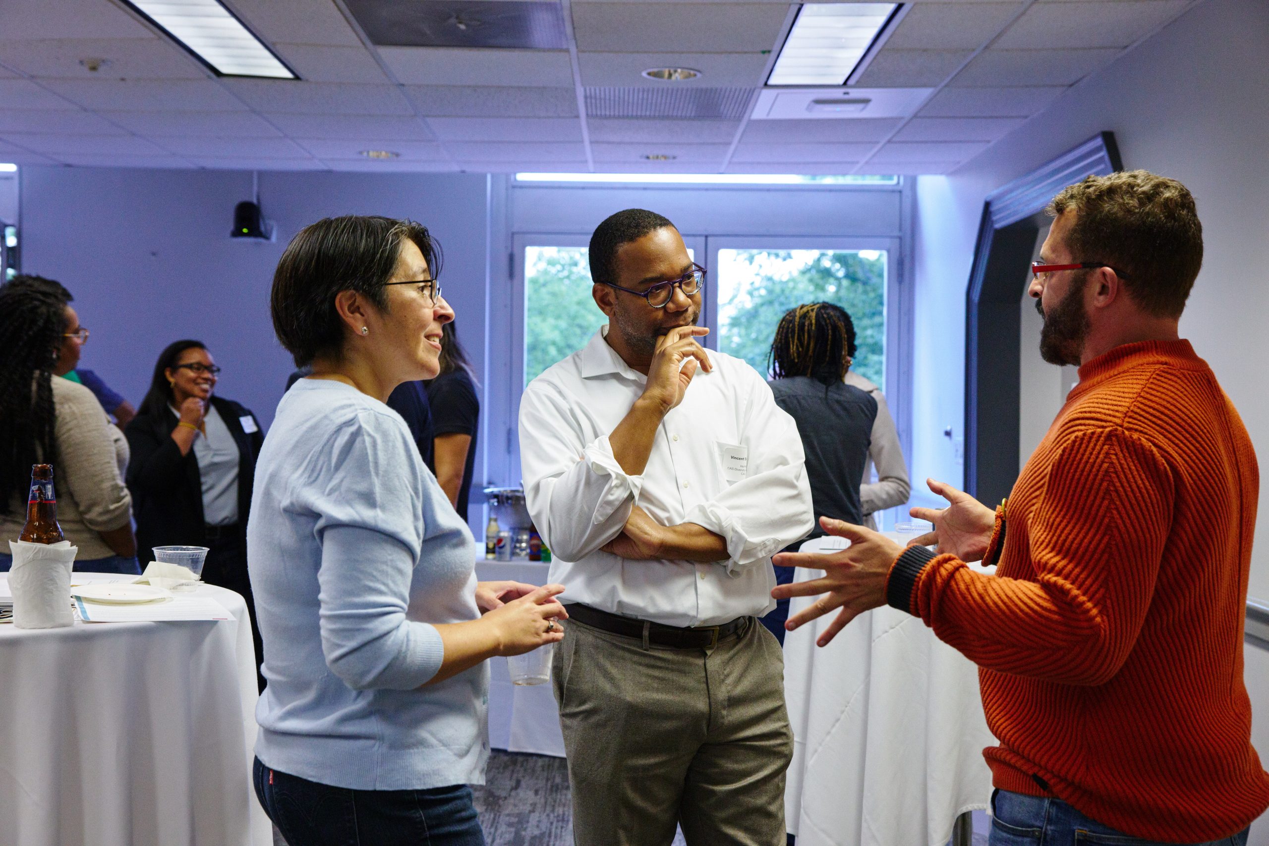 Three people standing in conversation