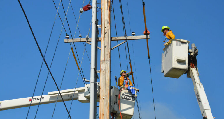 Workers using a lift to repair a utility line