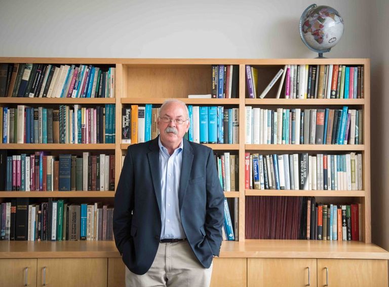 David Bishop standing in front of bookshelf