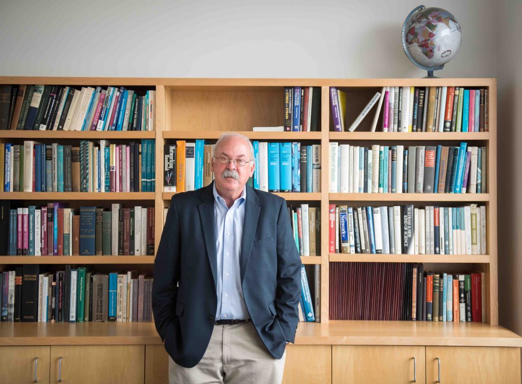 David Bishop standing in front of bookshelf