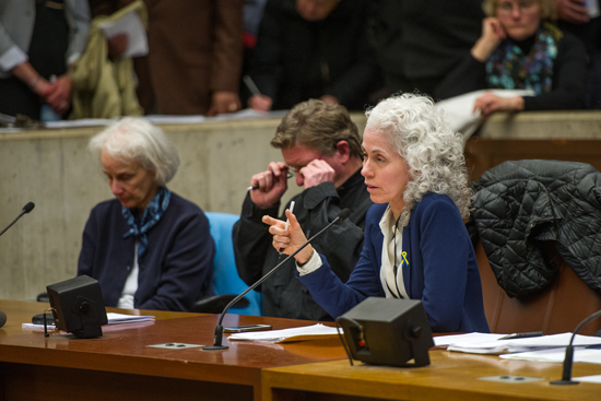 Barbara Ferrer (SPH’88), director of the Boston City Health Commission (BPHC), testifies at last night’s NEIDL hearing at Boston City Hall; at left is M. Anita Barry, director of the BPHC Infectious Diseases Bureau, and Boston Police Department Lieutenant Paul O’Connor.