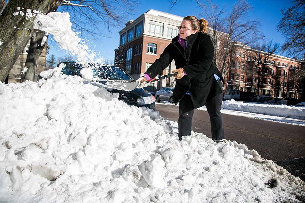 Emily Abrams (SSW '16), part-time research coordinator, cleans off her car Sunday morning after spending the night doing research at the School of Social Work. Photo by Kristyn Ulanday