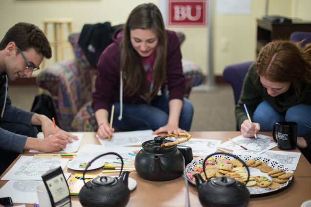 Tea Time, a Howard Thurman Center weekly initiative that introduces teas from around the world to participating students and allows them to engage in meaningful discussions about pressing global and domestic issues, brings students from across BU around one table. From left: Jacob Harrington (CAS'16), Dagny Barclay (SAR'17), and Emily Kausch (CAS'17) partake in a coloring activity, meant to serve as a stress-reliever, they said. Photo by Pankaj Khadka (COM'16)