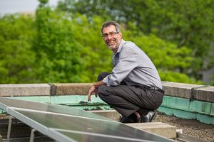 Robert Kaufman, professor of of earth and environment in Boston University’s College of Arts and Sciences, with rooftop solar panels at Boston University