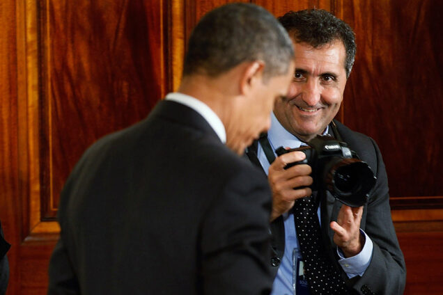 White House photographer Pete Souza, camera ready, with President Obama during an event celebrating the Affordable Care Act in 2010.
