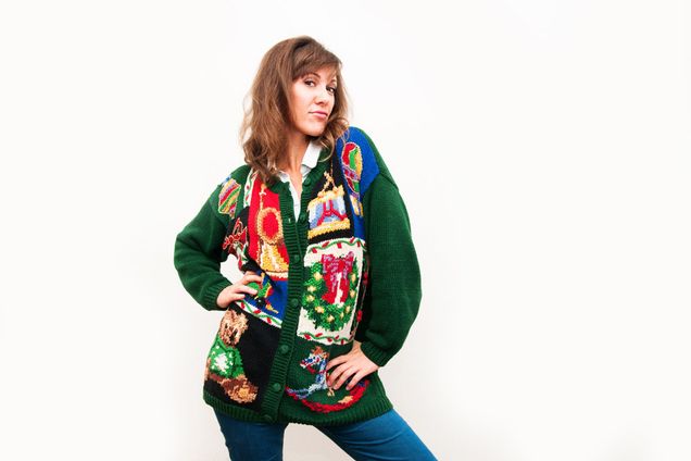 A young woman in a Christmas sweater strikes a pose.