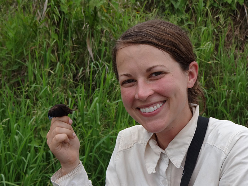 Graduate student Katie Stryjewski holds a Finch in New Guinea