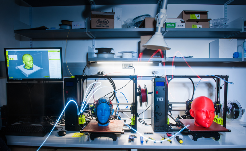 Two mannequin heads sit on tables in a BU Neurophotonics Center work space where new tools and technologies are built and tested.