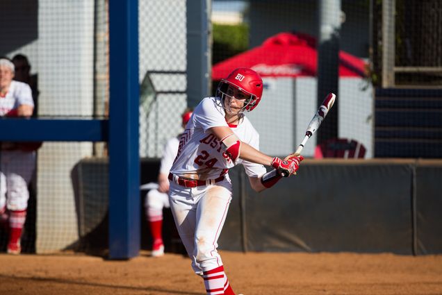 Brittany Younan swings a softball bat at home plate.