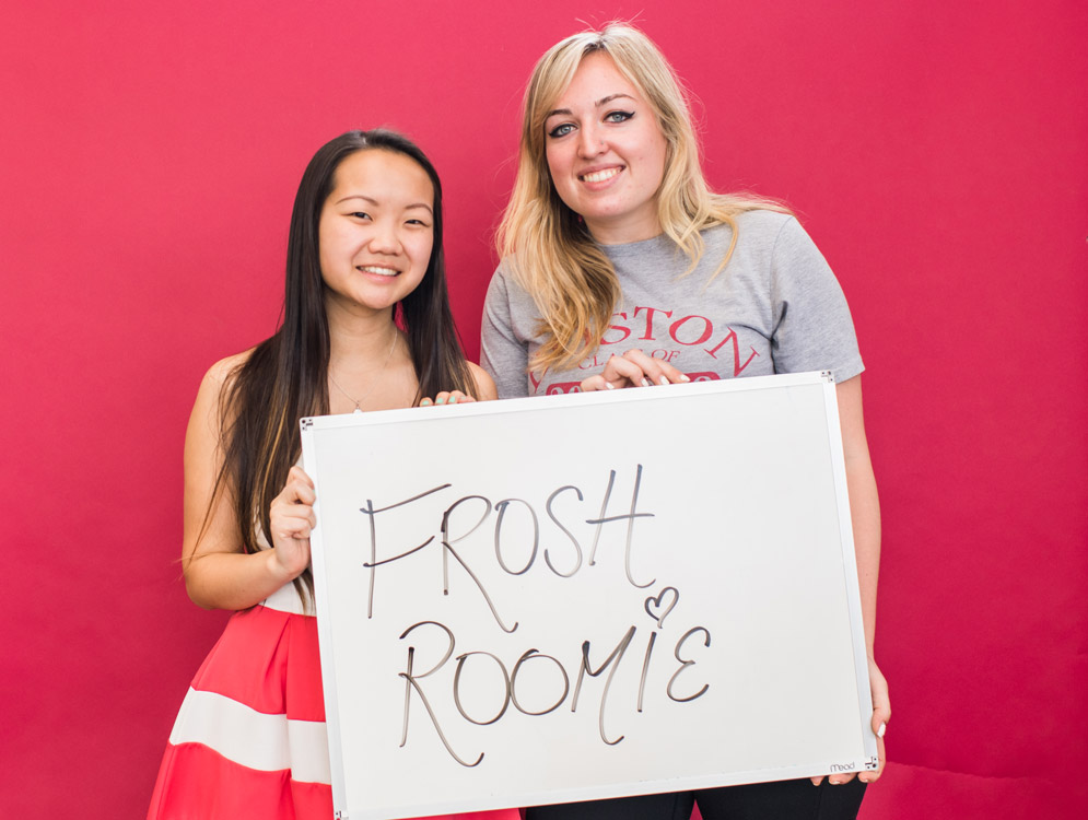 Class of 2018 students Mae Davis and Sky Digirolamo hold a sign saying they'll miss each other after leaving Boston University
