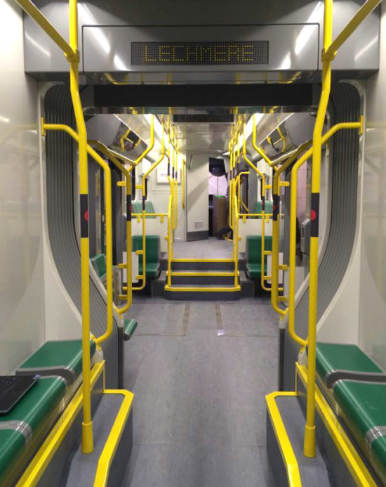 The empty inside of a new MBTA Green Line car showing seats and extra space