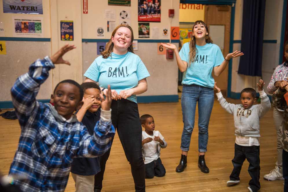 Students and kids laugh while dancing