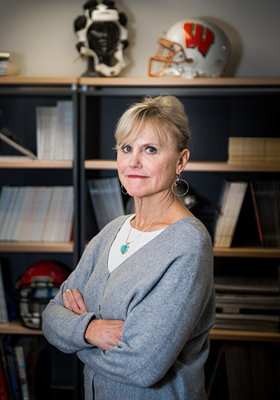 Portrait of Ann Mckee, professor of neurology and pathology at Boston University, chief of neuropathology at the VA Boston Healthcare System, and director of the BU CTE Center, in her office with arms crossed.