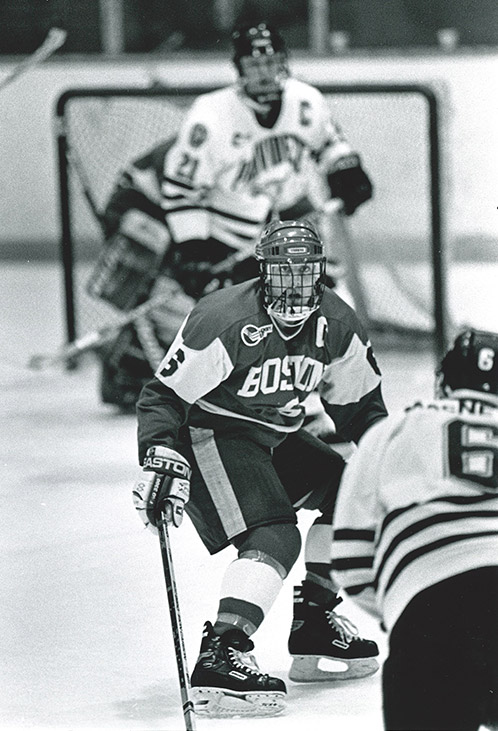 Game action photo of Albie O'Connell playing as a forward on the Boston University Men's ice hockey team.