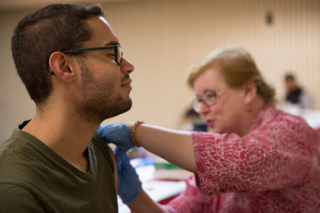 BU Student Health Services nurse Helen Lynch gives a flu shot to a student