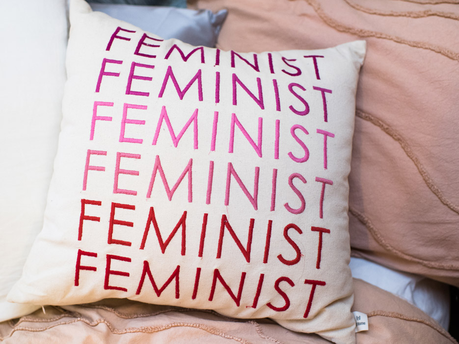 A pillow that has the word “Feminist” written on it