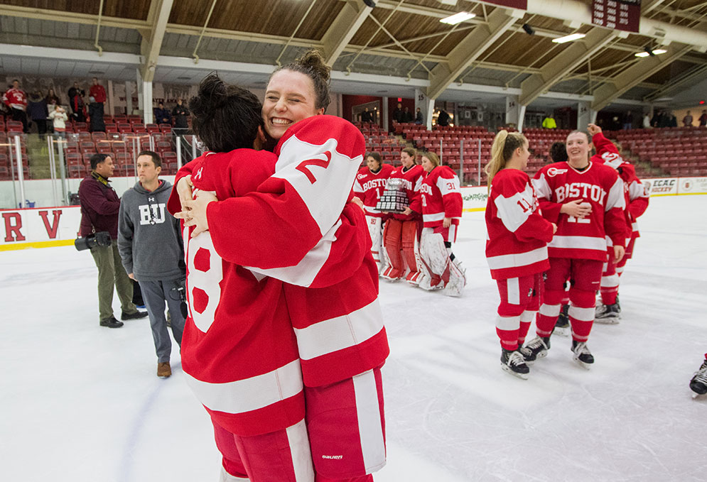 BU hockey players Reagan Rust and Alex Allan hug on the ice celebrating their winning the Beanpot championship.