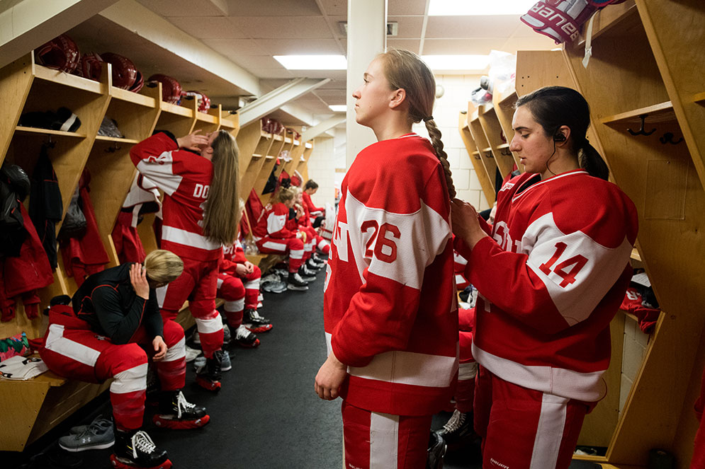 Members of the BU women's ice hockey team get dressed in the locker room before the Beanpot Tournament championship game
