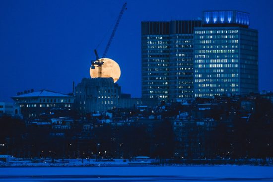 The super moon rises above the Charles on Tuesday evening