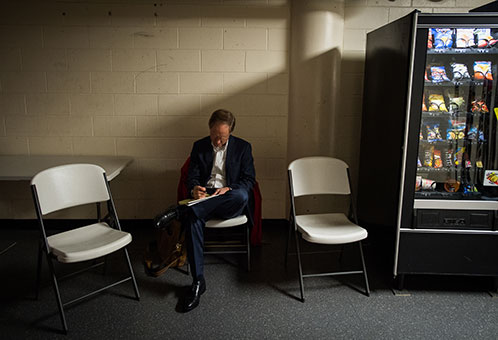 BU women's ice hockey head coach Brian Durocher sits alone in a lounge reviewing notes before the 41st Beanpot Tournament final game against Harvard.