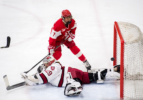 With the Harvard goalie laid out on the ice, BU women's ice hockey player Jesse Compher reacts to just missing the net after taking a shot on goal during the first period of the Beanpot championship