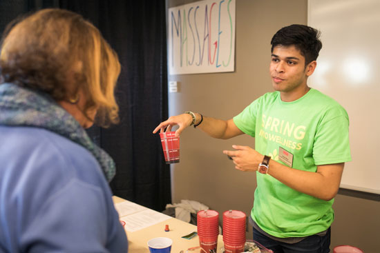 Avsar Rana holding a red cup during a presentation