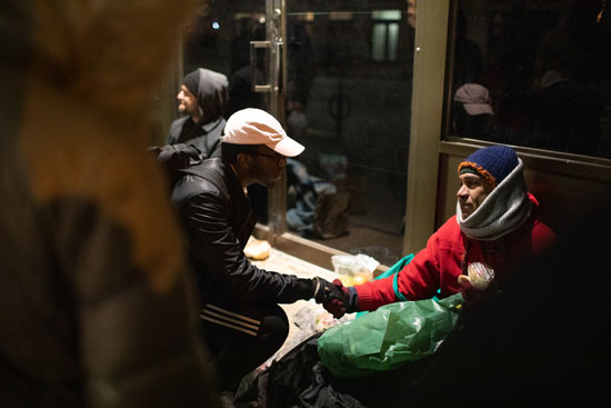 JJunior Anthony Dongfack (CAS) (left) comforts this homeless man during Swipes For Boston’s February run. The man became upset telling the him about immigrating from Brazil.