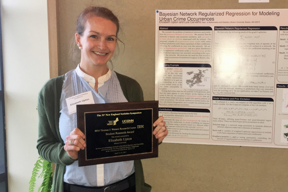 Liz Upton holding a plaque while standing next to some of her research