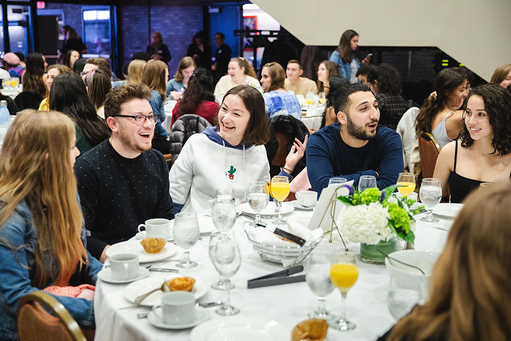 Students talk and laugh at the BU senior breakfast in Metcalf Hall, May 3, 2019.