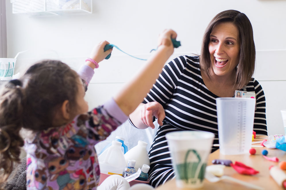 Kristy Berksza plays with a young patient at Newton-Wellesley Hospital. Berksza (Wheelock’05,’13)