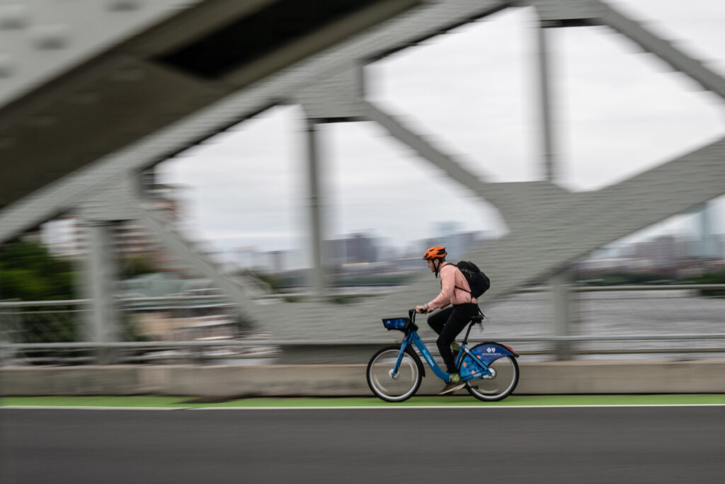 A bicyclist crosses the BU bridge