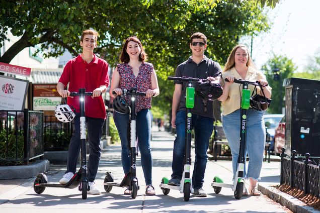 BU Today summer interns pose with Bird and Lime scooters