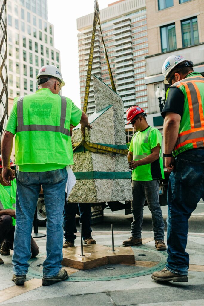 Construction crew installs the Boston Marathon Bombing Memorial stones on Boylston Street, Boston.