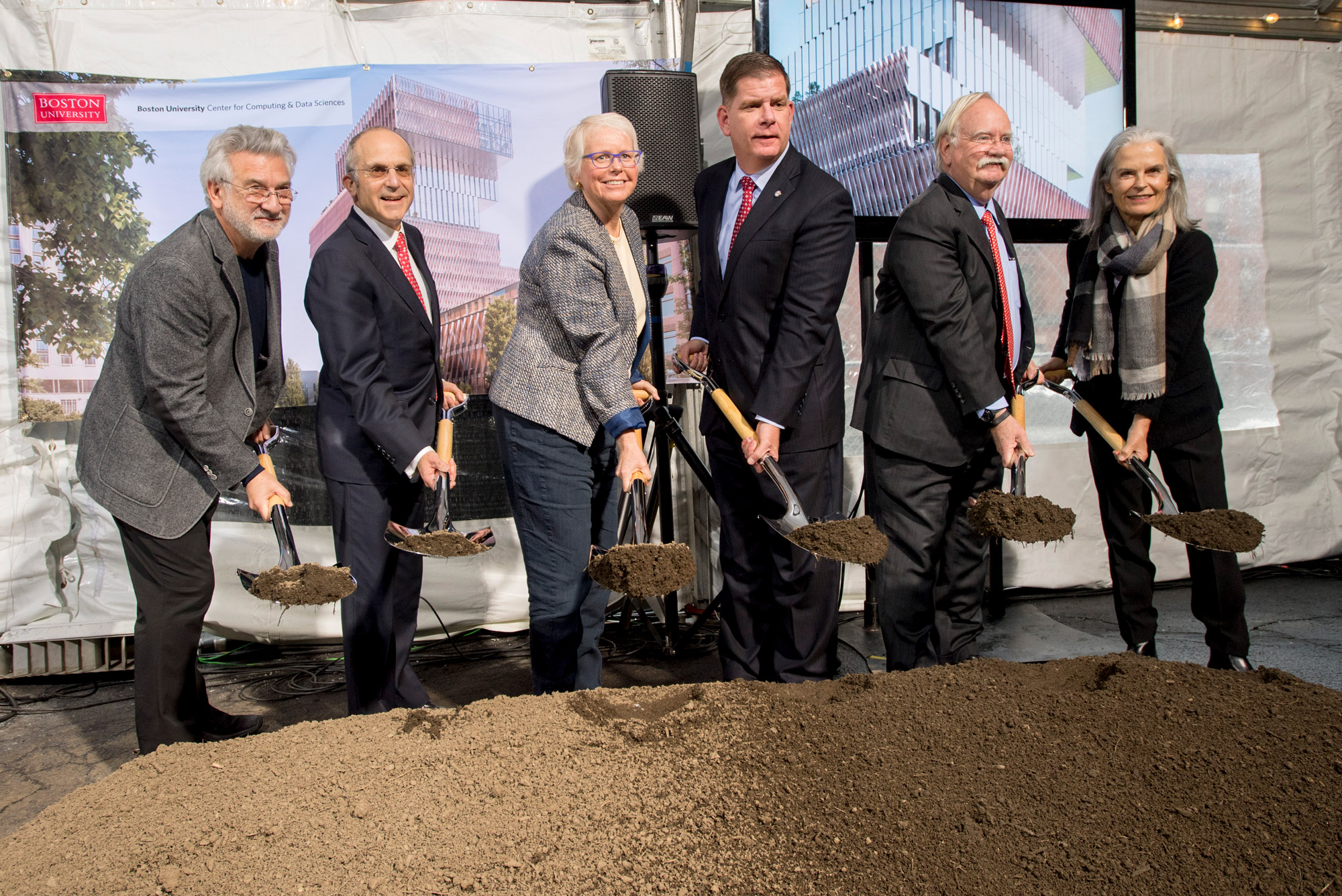 People hold shovels with dirt to celebrate the groundbreaking of the new Computing & Data Sciences Center