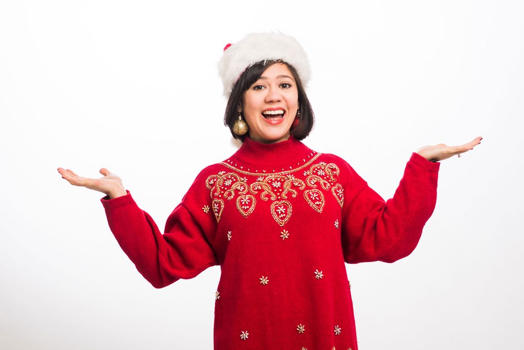 Cecilia Yudin wears a bright red holiday sweater with embroidery and a Santa hat