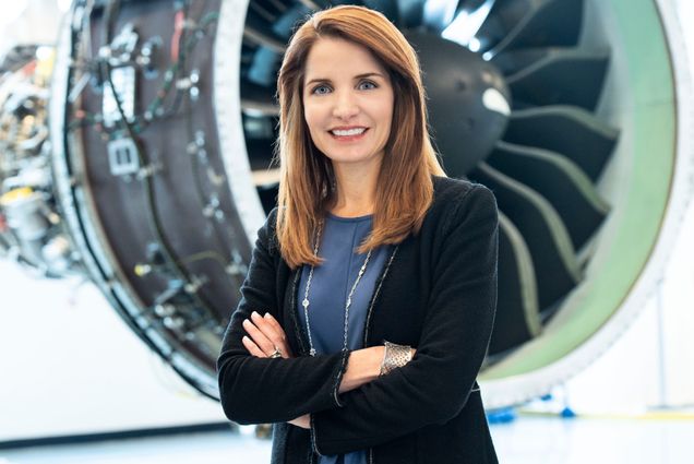 Jill Albertelli poses for a portrait in front of a jet engine.