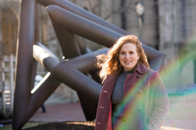Portrait of grad student Kimber Chewning in front of a piece of outdoor public art.