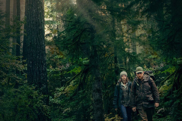 Still from the movie Leave No Trace; two young people walk through the woods of the Pacific Northwest