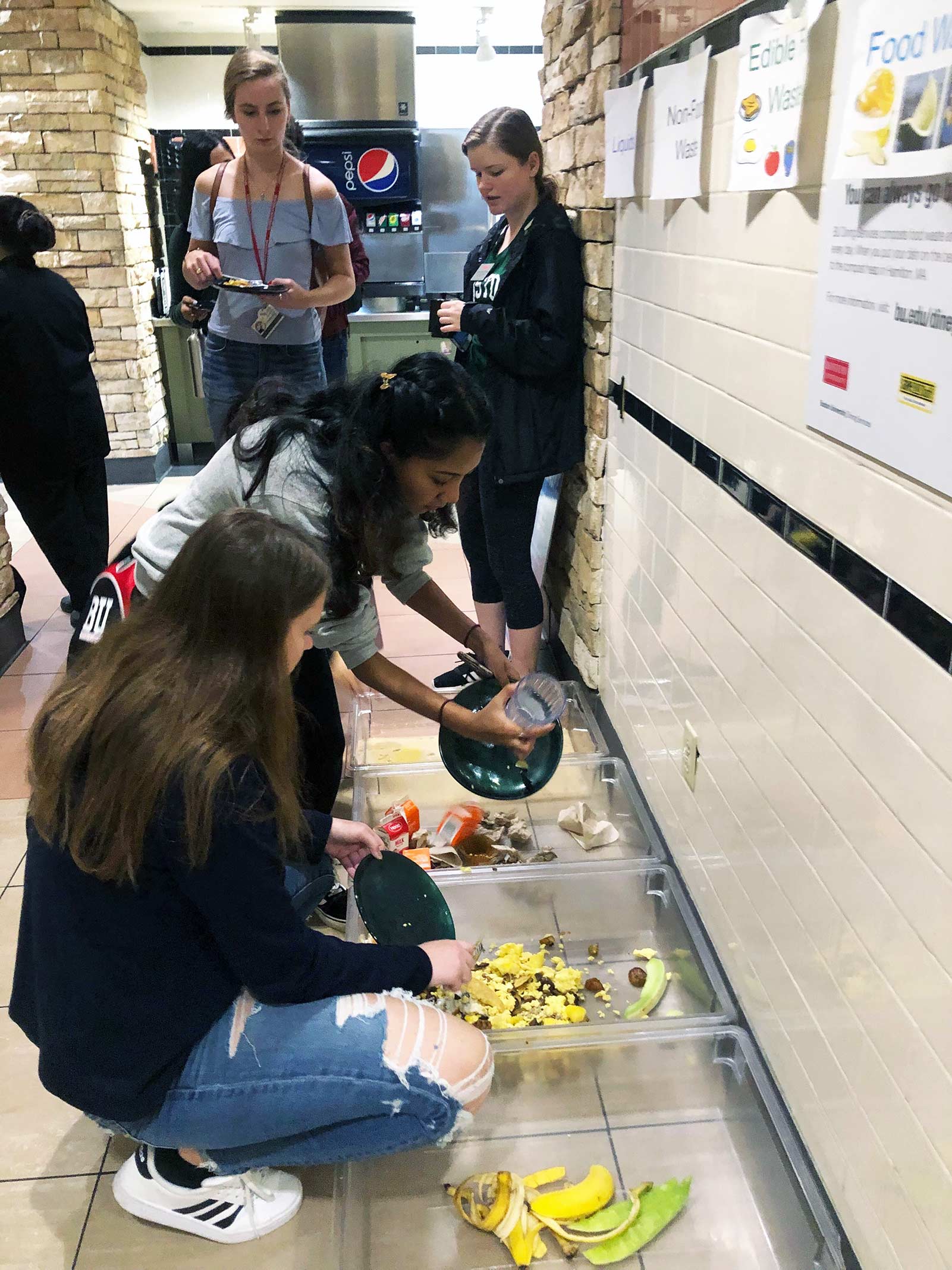 Boston University students separate food waste into containers as part of a 'Weigh the Waste' event to help identify opportunities for reducing food waste on campus.
