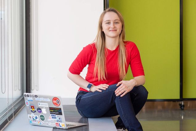 Portrait of Elizabeth Slade (ENG’20), Cofounder and director of BU chapter of Hack4Impact, sitting with her computer open off to the side.