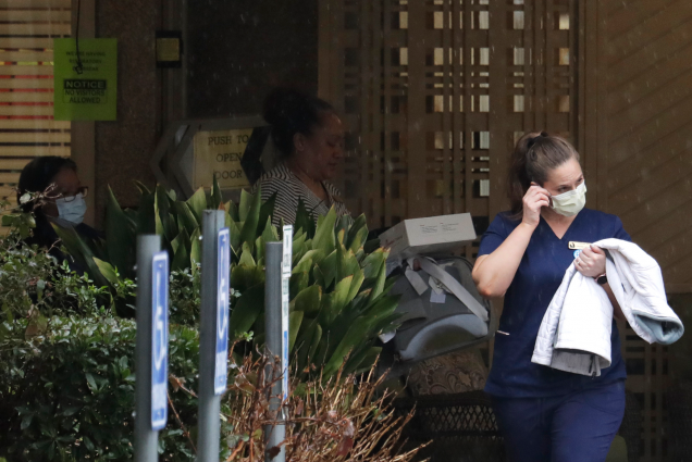 A worker at the Life Care Center in Kirkland, Wash., near Seattle, wears a mask as she leaves the building