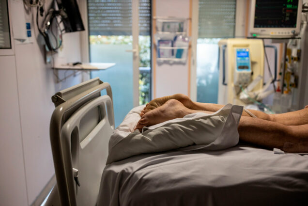 A photo of a COVID-19 patient lying prone on a hospital bed