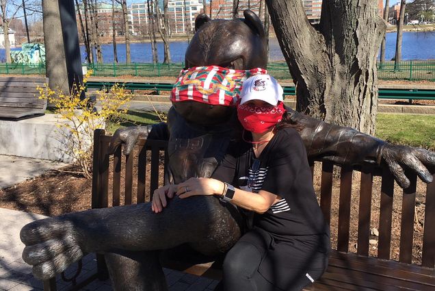 Image of Dr. Joan Salge Blake, a Sargent College clinical professor of nutrition, sitting on the Rhett bench. Taking the advice of Governor Baker, both Joan and Rhett are wearing masks whenever they leave the house.