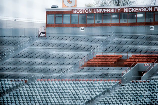 Photo of empty bleachers at Nickerson field on an overcast day, April 27, 2020. Gatorade and Boston University signs rest atop the announcer's box.