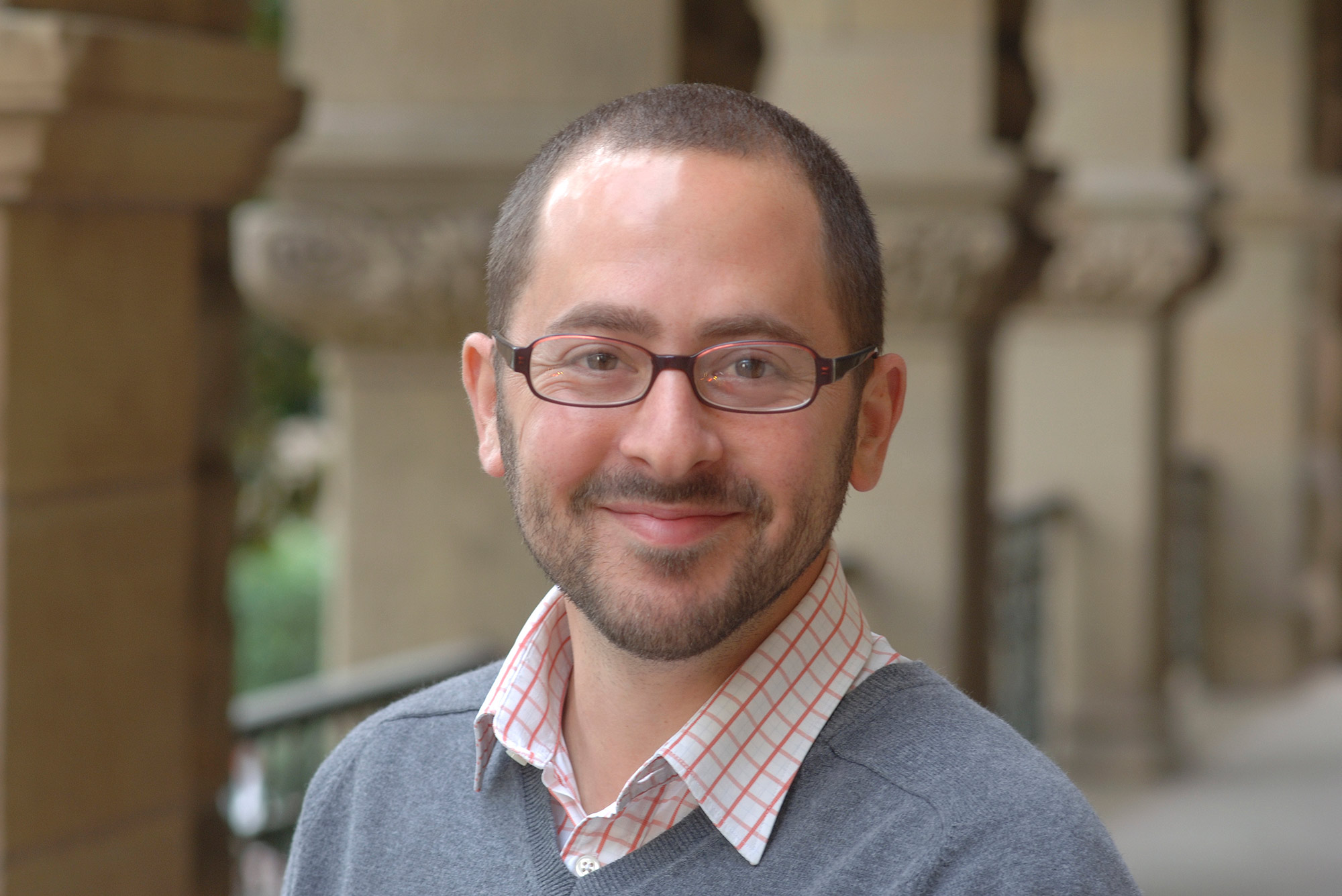 Portrait of The Pardee School of Global Studies’ Jeremy Menchik in a gray sweater with blurred columns in the background.