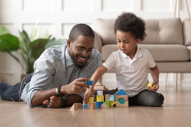 A photo of a father and son playing with wooden blocks together