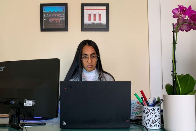 Photo of Pawandeep Kaur sitting at a desk with a computer as she works. Kaur is in SPH’s Doctor of Public Health program, and is juggling her volunteer responsibilities with her coursework and her full-time job as a clinical trial director at SPH.