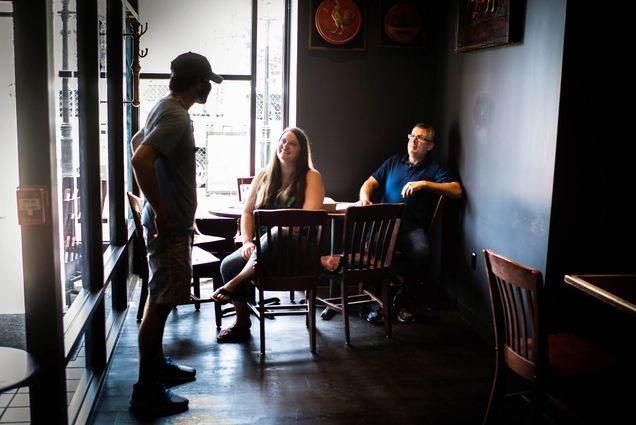 A photo of server Jeffrey Ney along with patrons Chris Strang and Laura McDougall in Cornwall's Pub